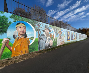 Explore the rich history and vibrant future of East Providence through a stunning 200-foot mural on the Crescent Park Beachfront Wall. Featuring Native heritage, local landmarks, and iconic symbols, this artwork celebrates the city’s cultural resilience and scenic beauty