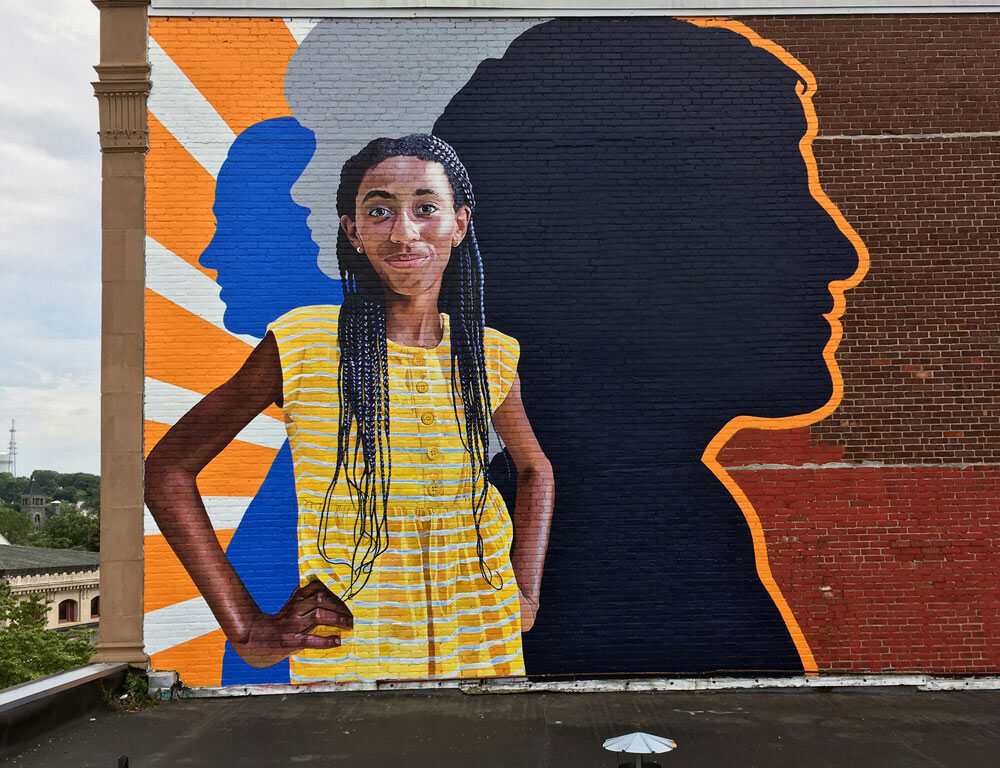 Fearless Girl Mural painted on the exterior of Beacon Charter High School in Woonsocket, RI by Charles C. Clear III and Bonnie Lee Turner